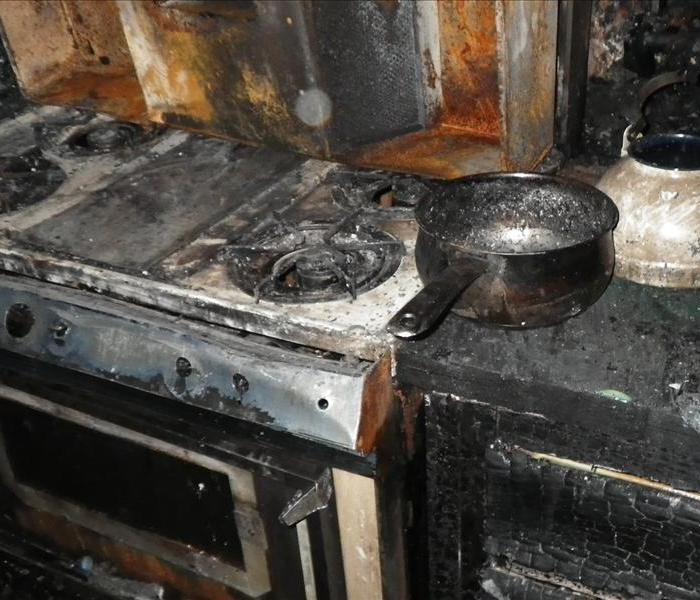 Kitchen fire due to a stove top accident. Very badly burned stove, and kitchen cabinets.