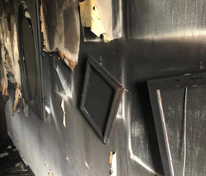 Fire scorched wall with photo frames in an apartment complex fire.  