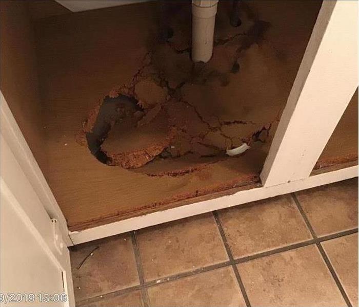 Water damage under sink causing cabinet flooring to fall apart