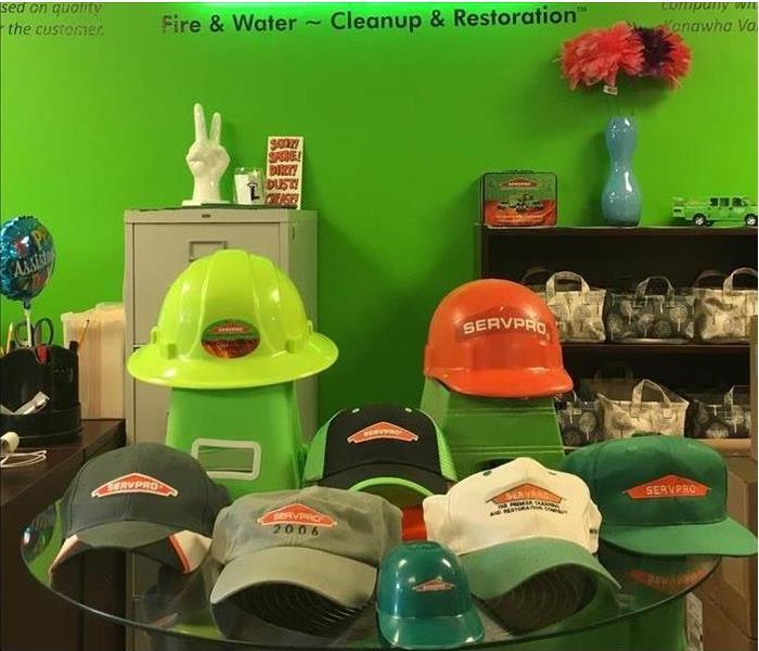 A table with many different hats on it symbolizing the many hats that our staff at SERVPRO wear.