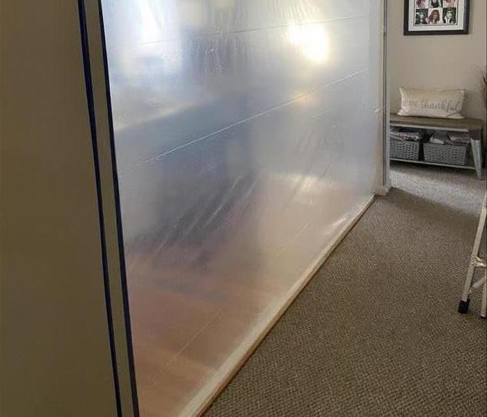 A containment barrier between a kitchen and living room