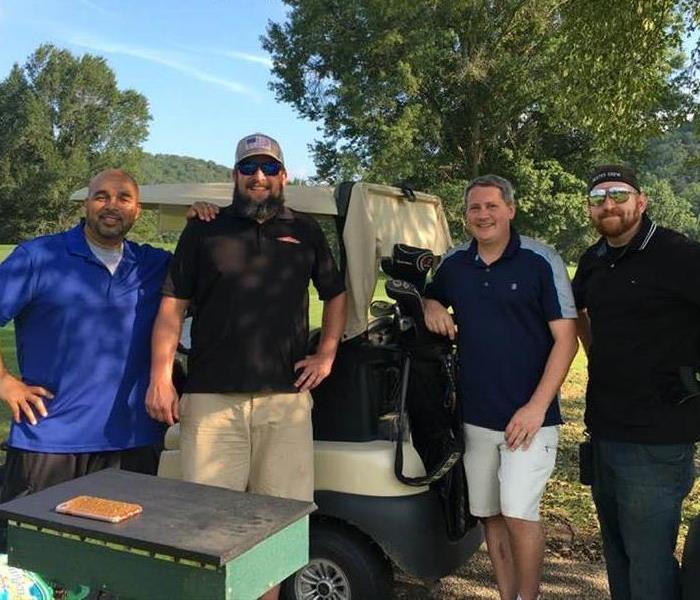 Golf Team standing in front of golf cart